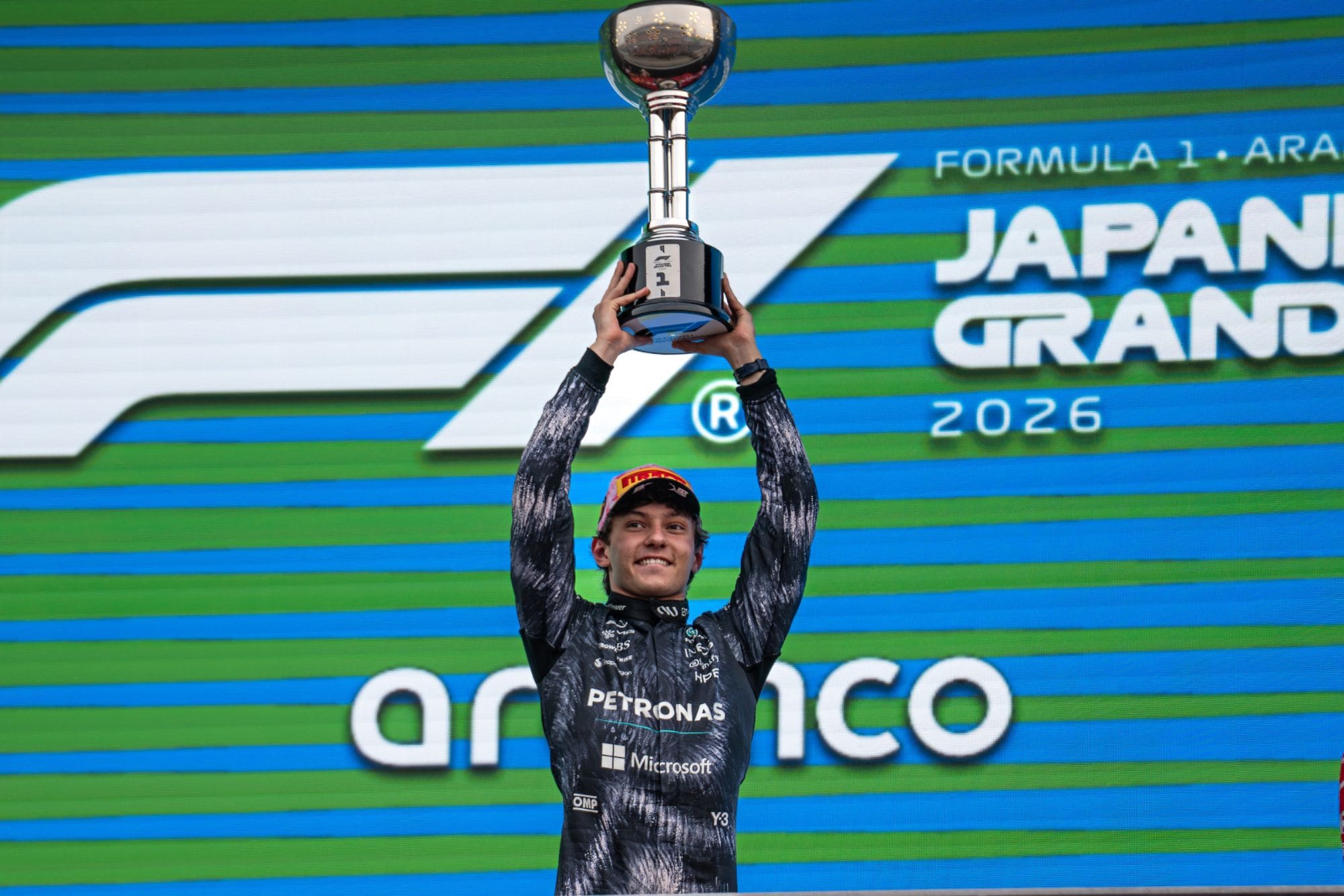 Kimi Antonelli lifts the winner's trophy on the podium at the 2026 Japanese Grand Prix