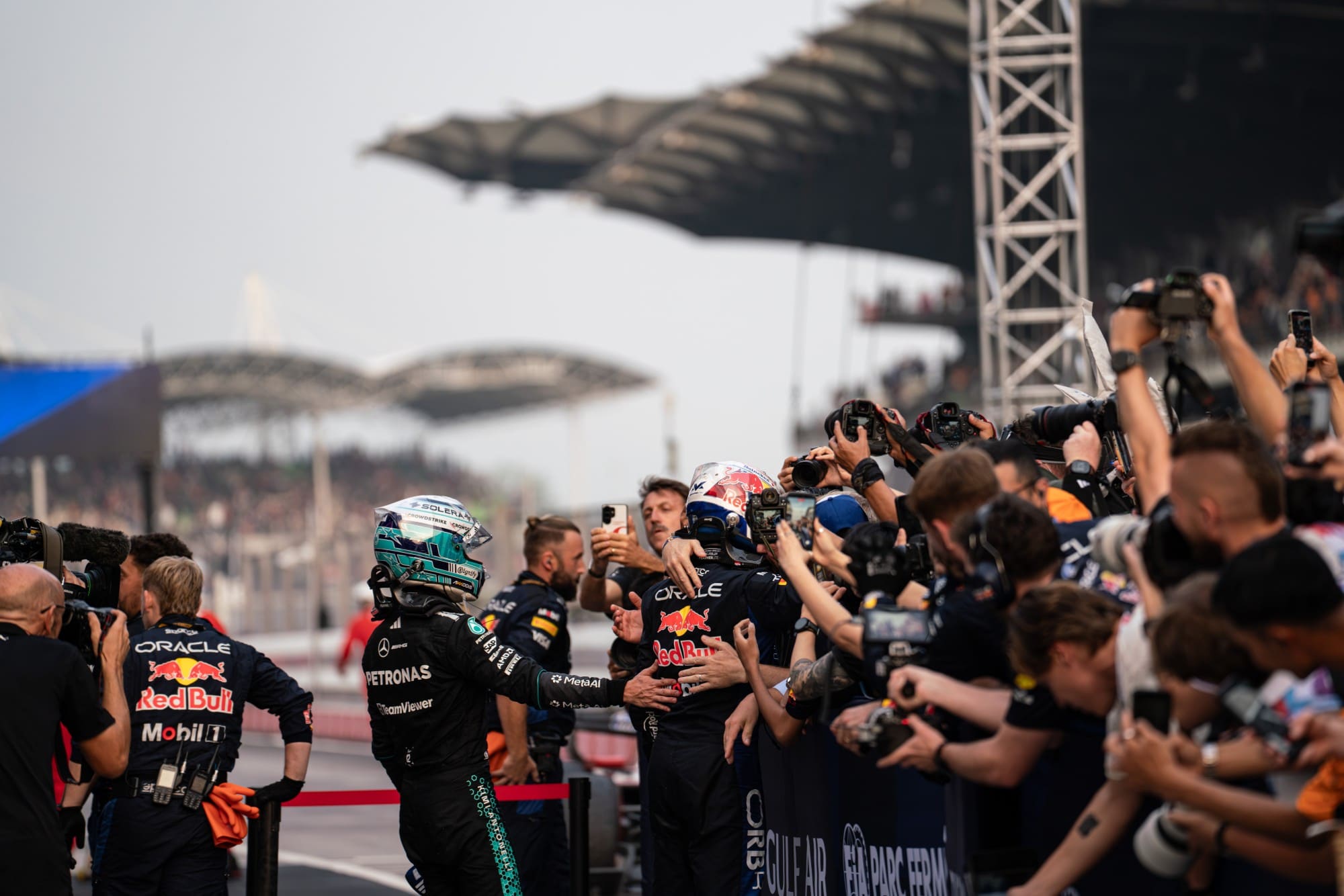 Kimi Antonelli congratulates Max Verstappen as he celebrates with his Red Bull crew in parc fermé