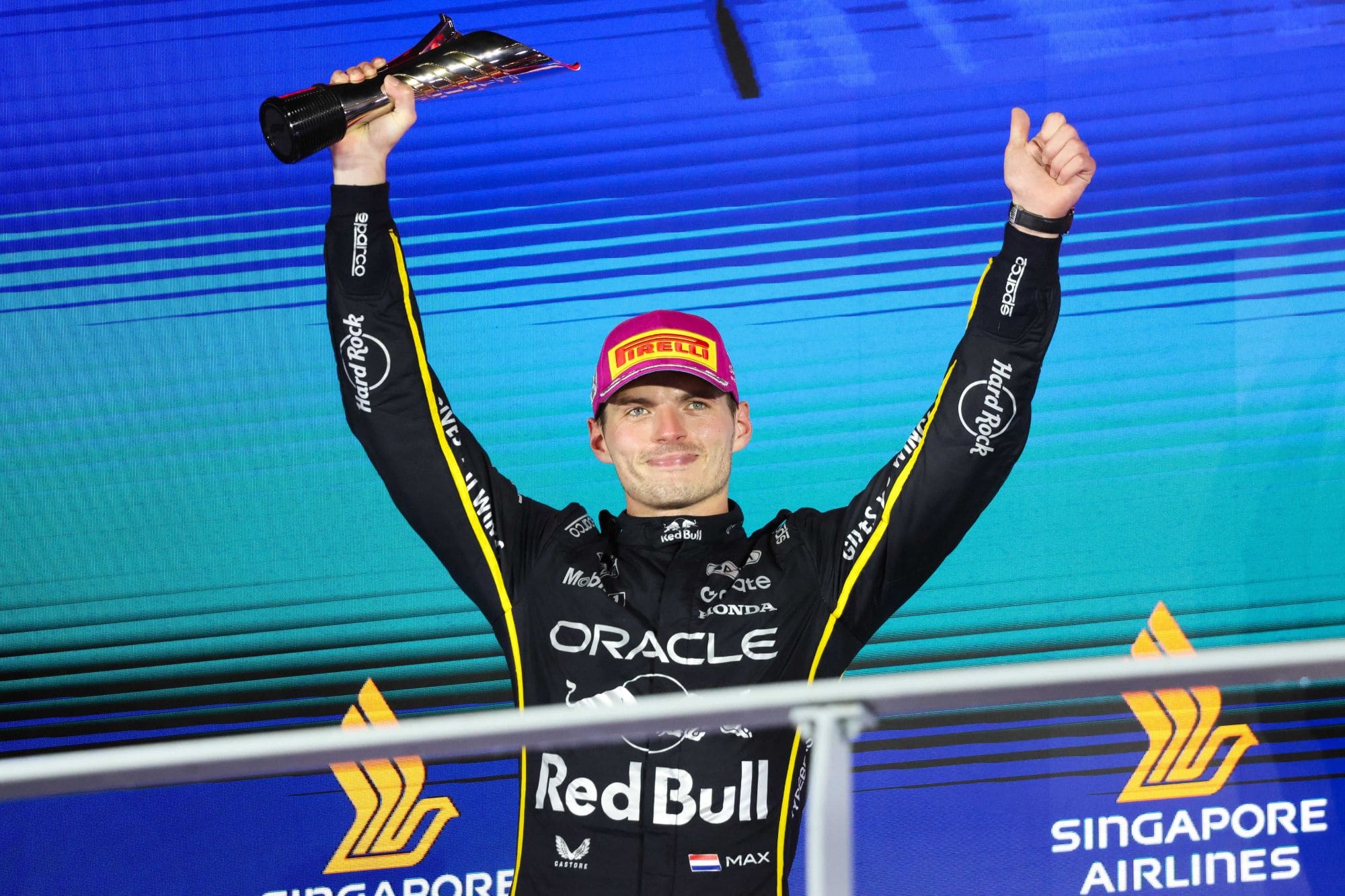 Max Verstappen raises his trophy on the podium at the 2025 Singapore Grand Prix