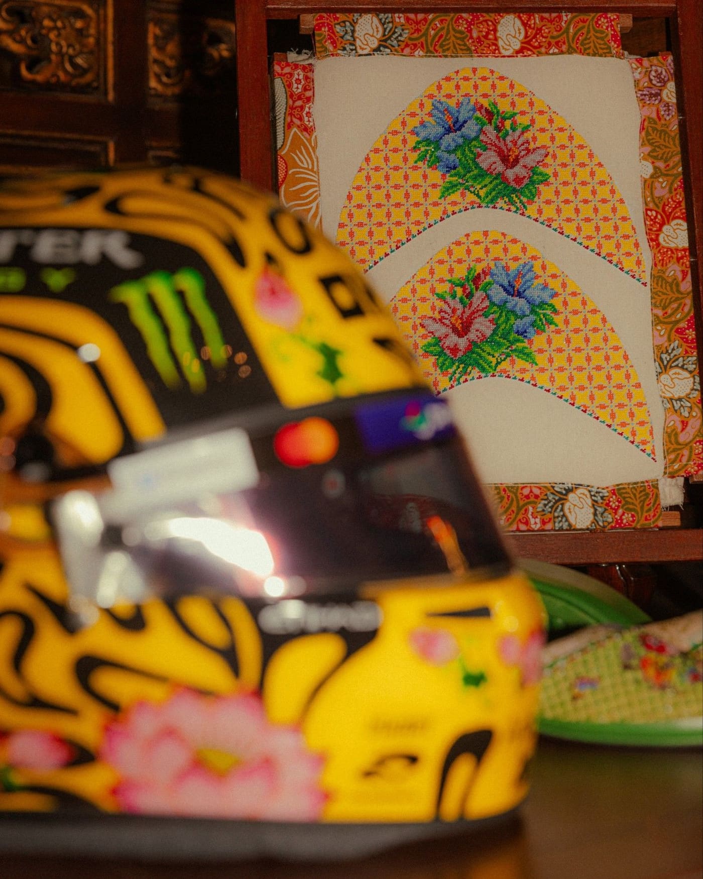 Lando Norris’s helmet in front of beaded slipper uppers stretched on a wooden frame