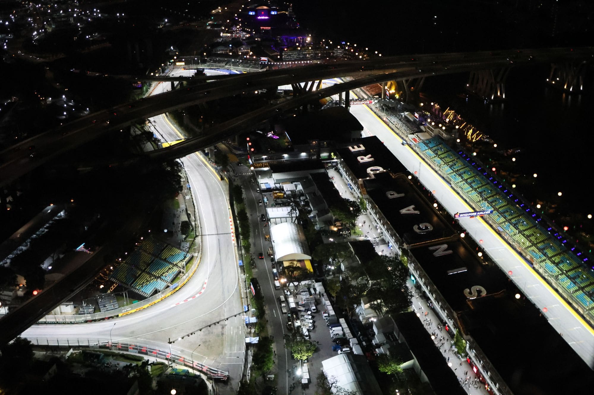 The Marina Bay Street Circuit, pit building and main grandstand lit up at night, seen from above