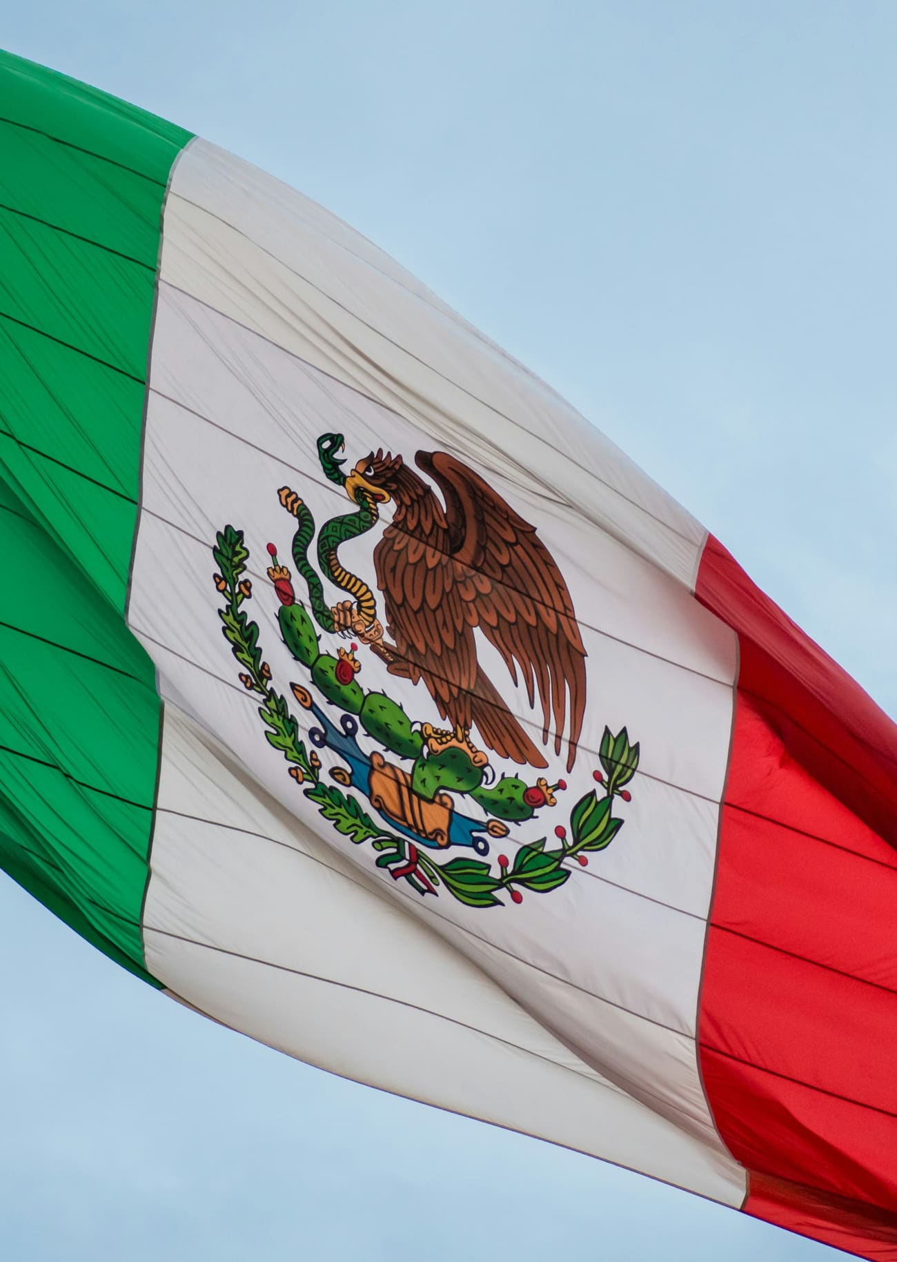 A Mexican flag flying against the sky