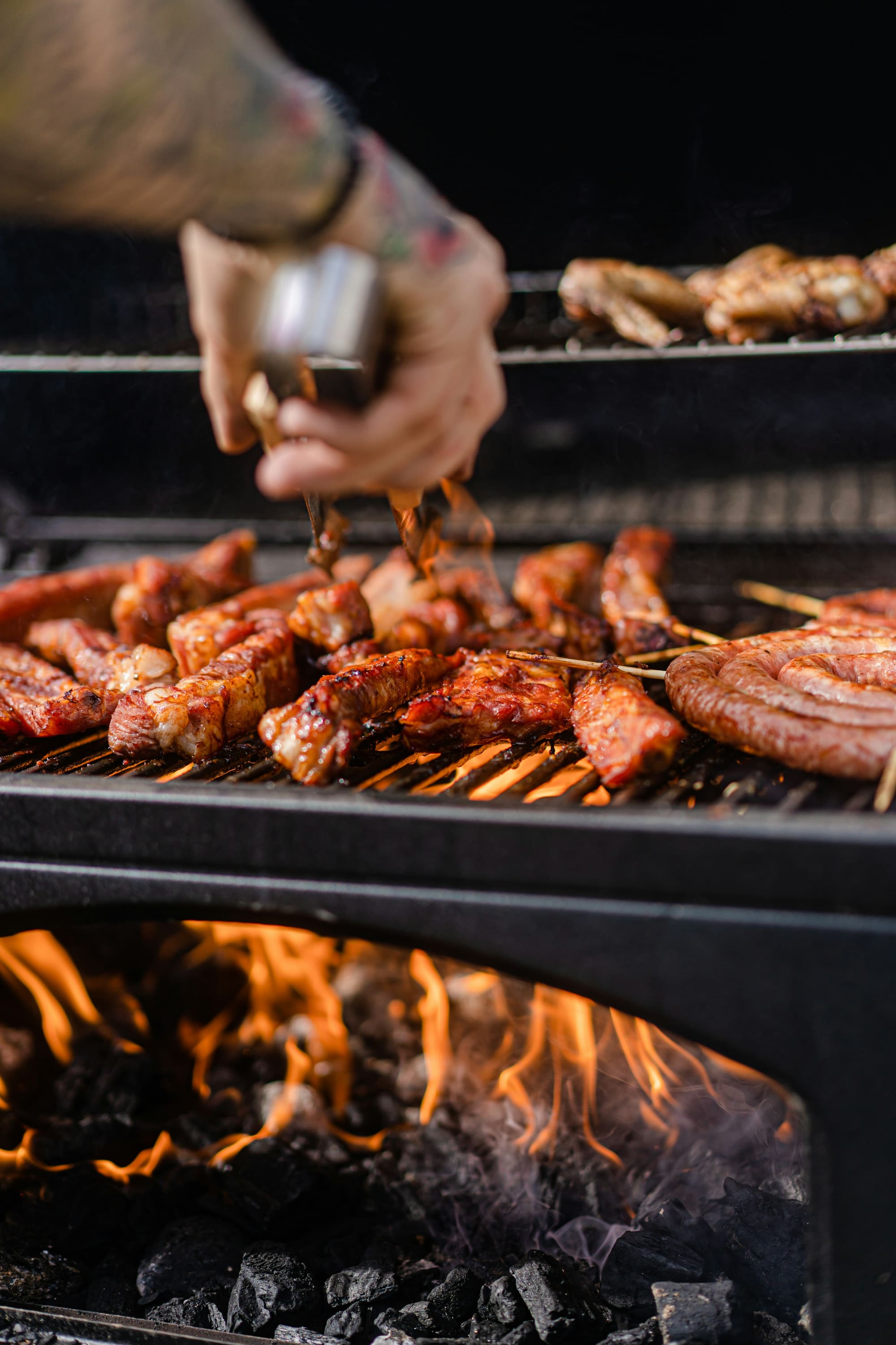 Meat skewers and sausages cooking on a charcoal grill